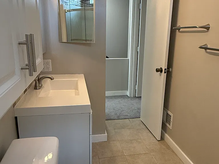Full view bathroom to hall area
Tile floor, ample mirrors, and storage