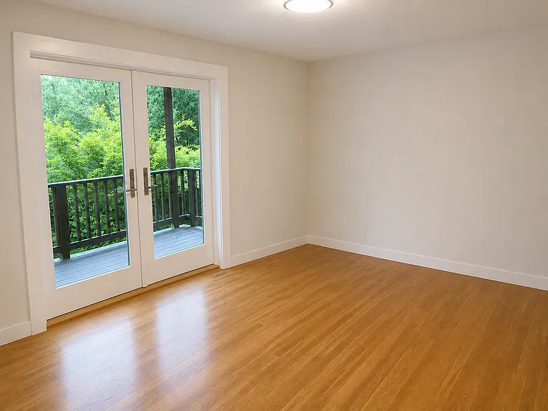 Primary bedroom with french doors to lower deck and backyard