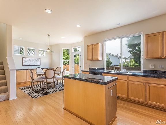 The kitchen opens to the dining space, both with views of the expansive backyard. 