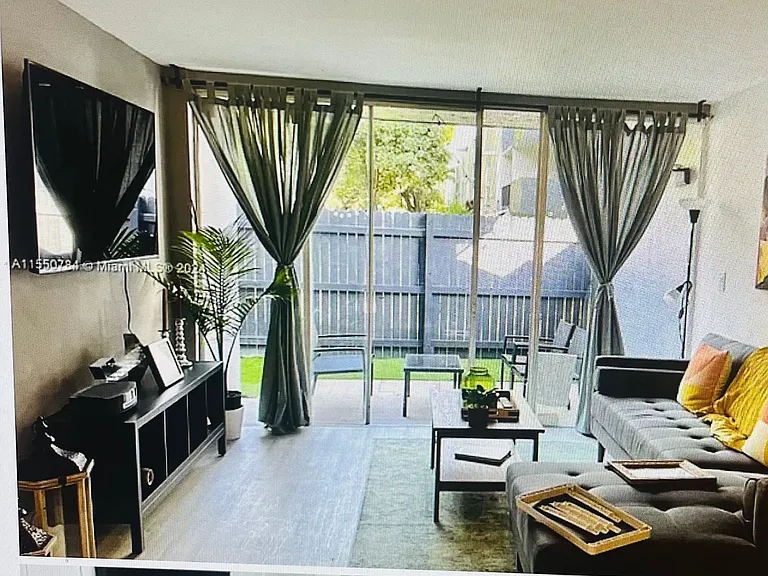"The living room is spacious and bright, with large windows that let in plenty of natural light. It offers a comfortable area for relaxing or entertaining guests."