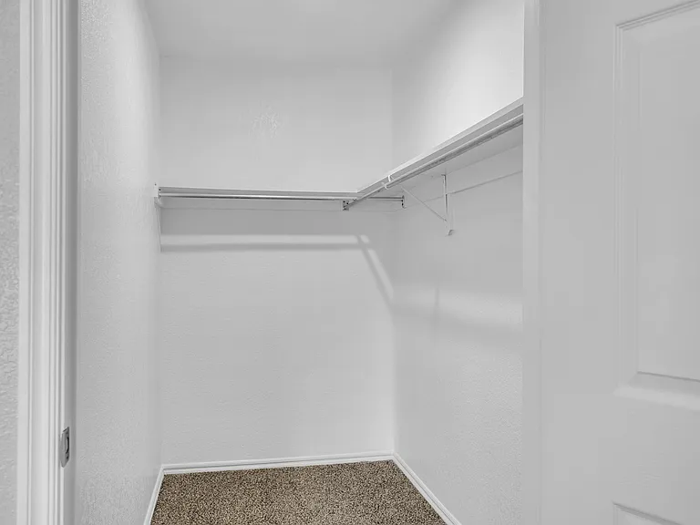 Bright and spacious walk-in closet with ample shelving and modern design. Bright and spacious walk-in closet with ample shelving and modern design.