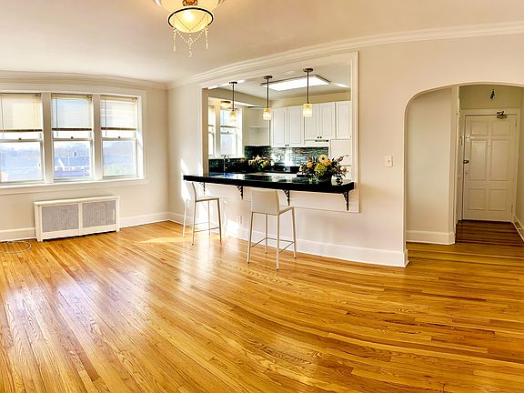 Living room showing front entrance and open counter to kitchen