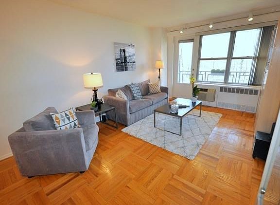 Bright living room has a door leading to a balcony that is great for enjoying the outdoors.  The living room opens to the dining foyer and has parquet floors.  The room is 30'-2" by 12'-4".