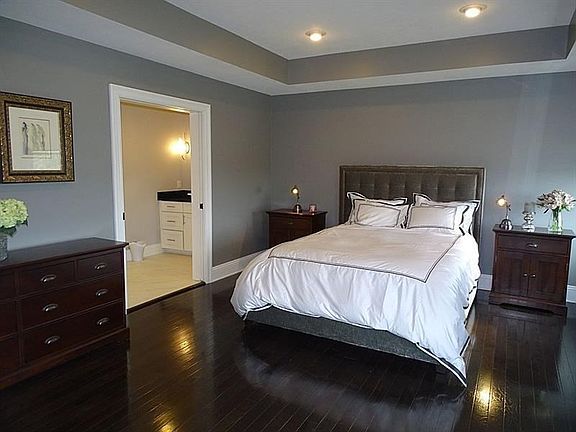 The master suite boasts crown molding and a trayed ceiling with recessed lighting and built-in speakers.