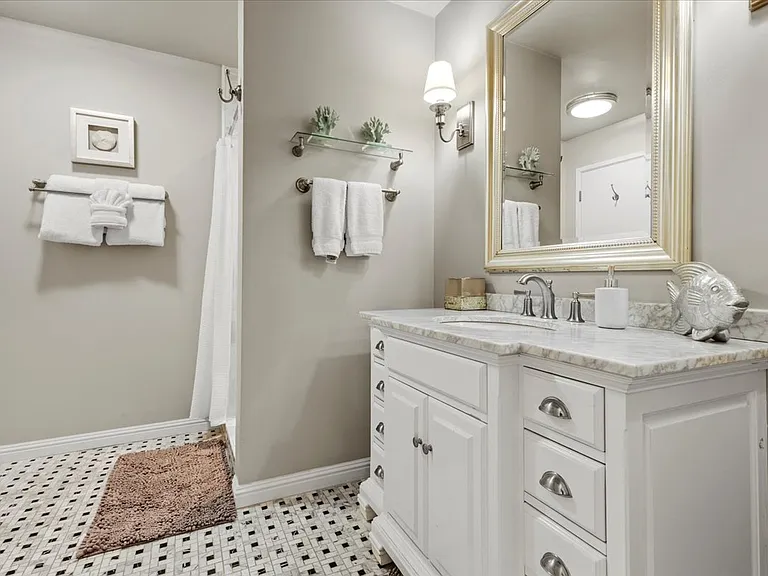 Guest Bathroom with large tiled shower and all tile floor marble top vanity sink area