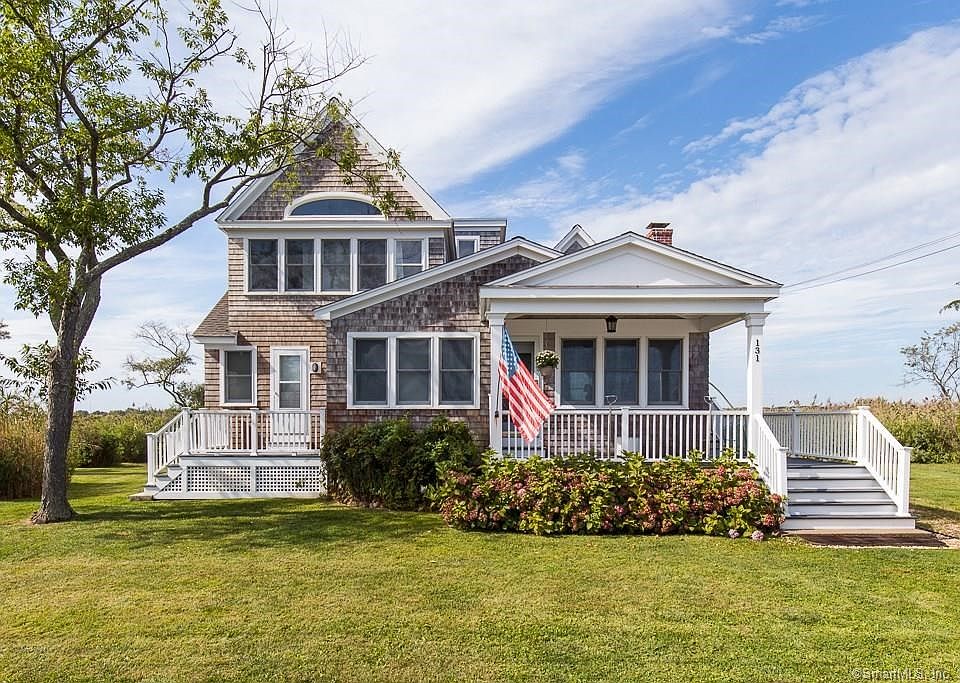 Exterior front picture of 131 Neck Rd in Guilford CT. Note there are two front decks - one at the front steps and entrance. A second deck at the left is off of one of the two first floor bedrooms.