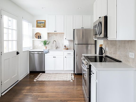 Charming kitchen with shaker cabinets and brand new appliances including refrigerator and microwave.