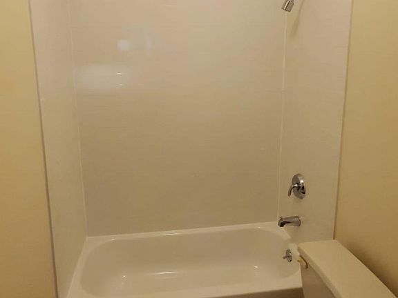 Full bathroom with high ceilings and a linen closet
