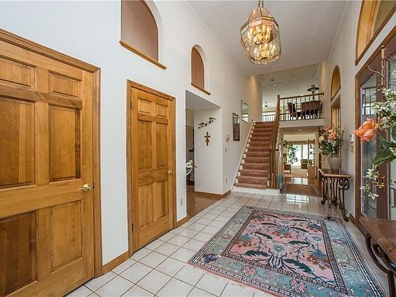An elegant two0story entry features dual glass doors, two coat closets & half bath