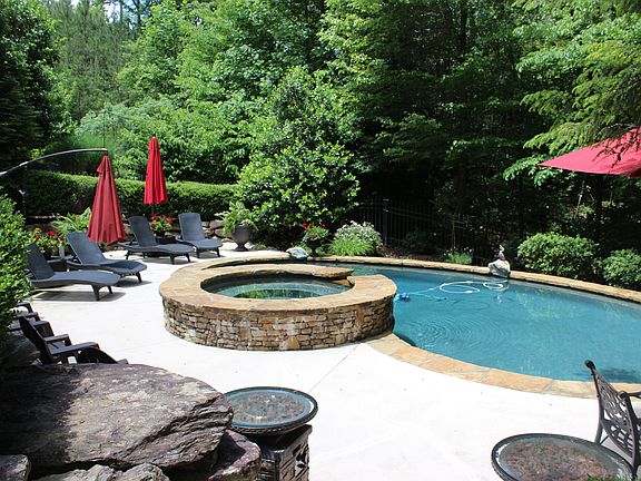 Lighted pool area with woods