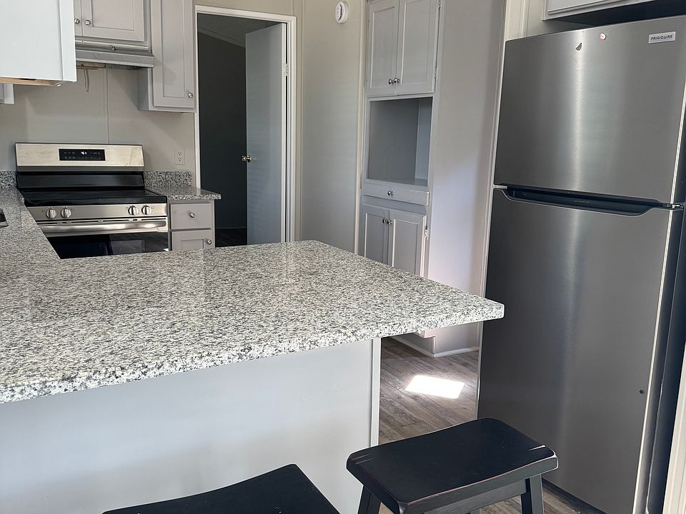 Kitchen with all new light grey cabinets, oven, refrigerator, granite counter tops