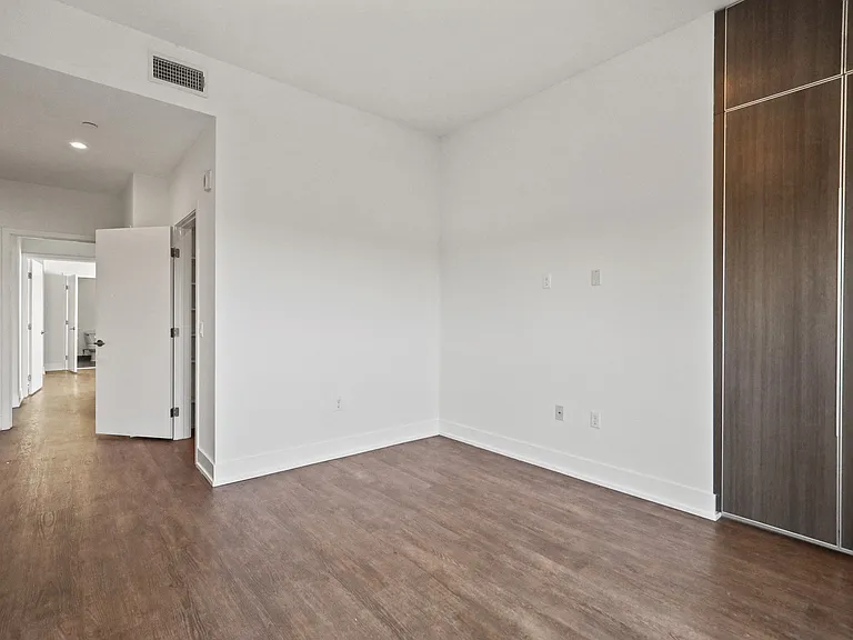 Bedroom with Vinyl Flooring, Bathroom, and Built-In Storage Cabinets