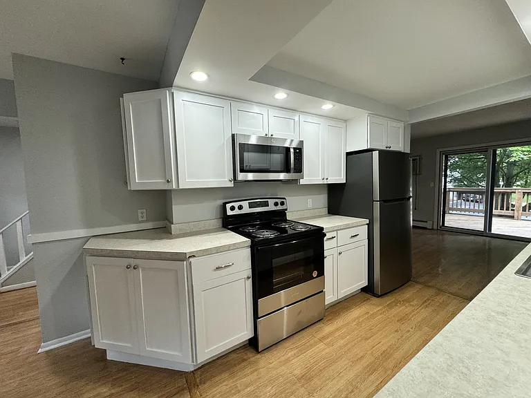 Kitchen with new appliances. Refrigerator, stove/oven, microwave.