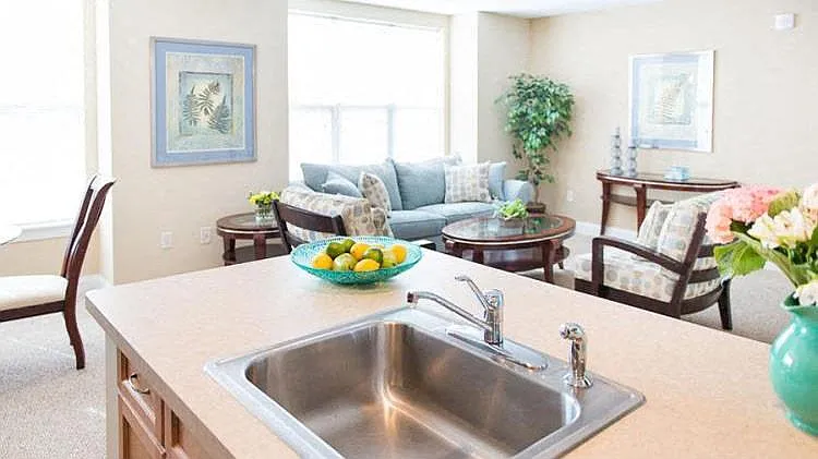View of great room from kitchen showing large living area, bright windows, and part of dining area