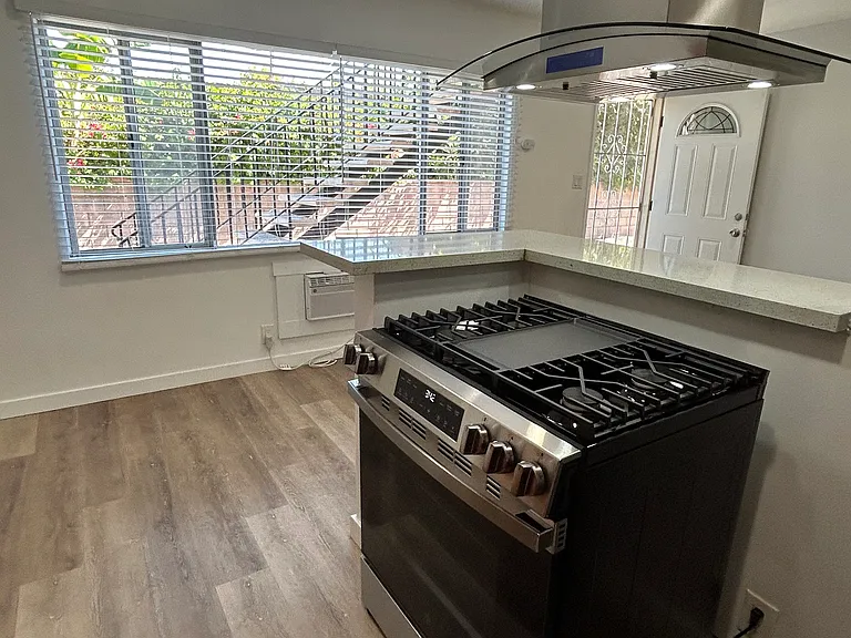 View from kitchen, brand new stove, natural light from window.