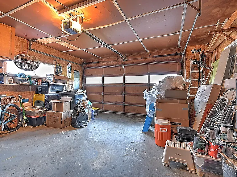Empty two-car garage with an automatic door that pairs with your vehicles.