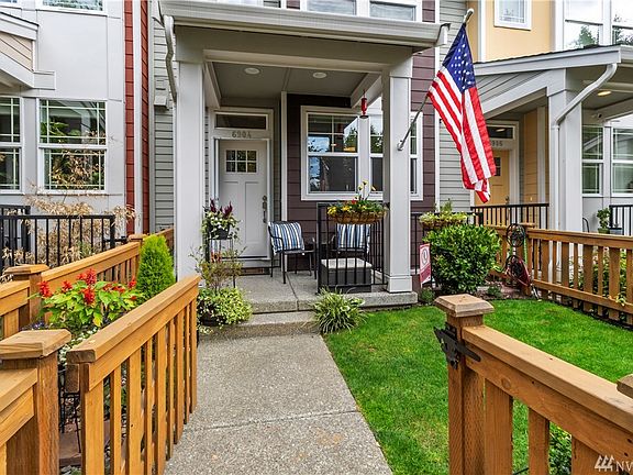 Fully fenced front yard with patio is beautifully landscaped and easily maintained.