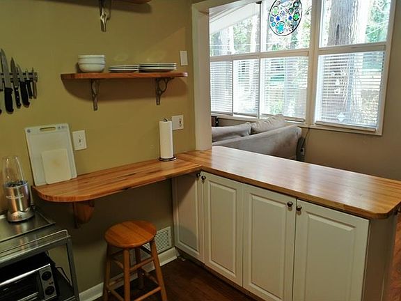 This shot shows the wall removed and breakfast bar with extra storage and eat-in area.  Fashionable open shelving as well.