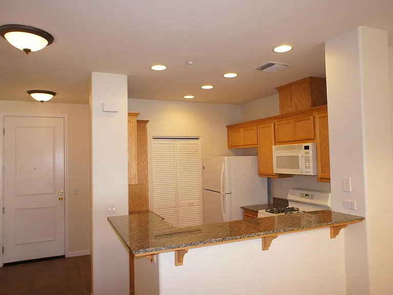 Kitchen with recessed lighting, gas stove, microwave, dishwasher, as well as full size washer and dryer in the laundry room