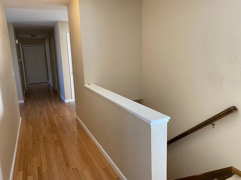 Upstairs hallway and then stairs to the right, going to the downstairs.