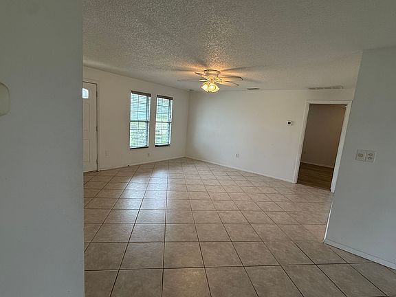 living room, looking toward front windows and master bed w master bathroom