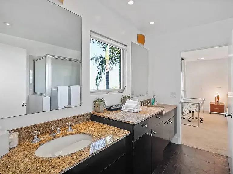 Experience luxury in the ensuite bathroom with elegant marble countertops, featuring his and hers sinks for added convenience.
