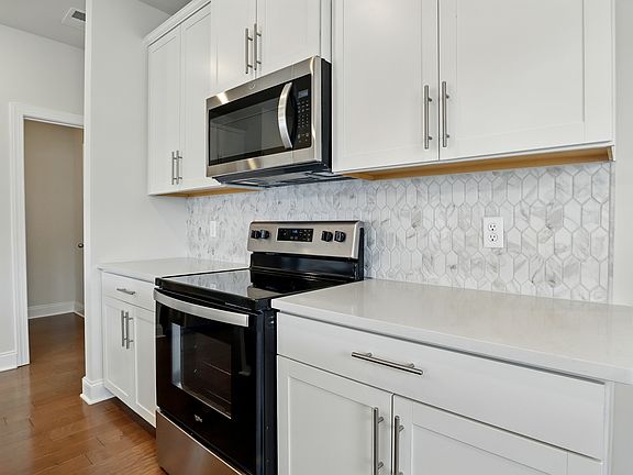 Kitchen - Custom tile backsplash, extensive cabinet space, and modern finishes designed for everyday functionality and style.