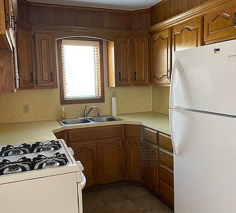 Kitchen w/ gas stove and fridge, stainless sink and ceramic tile flooring, laundry in garage