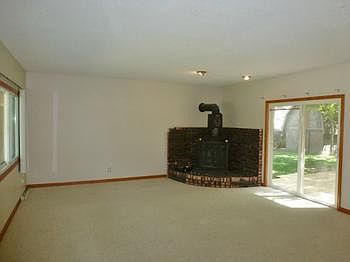 Enormous living room with lots of windows and a wood burning stove.  Sliding doors lead out to the deck!