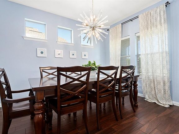 The large dining room has ample light, wood look tile flooring and plenty of space.
