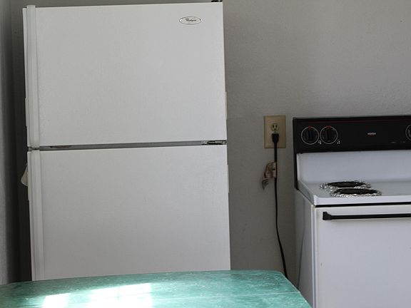 Fridge stove and table in kitchen