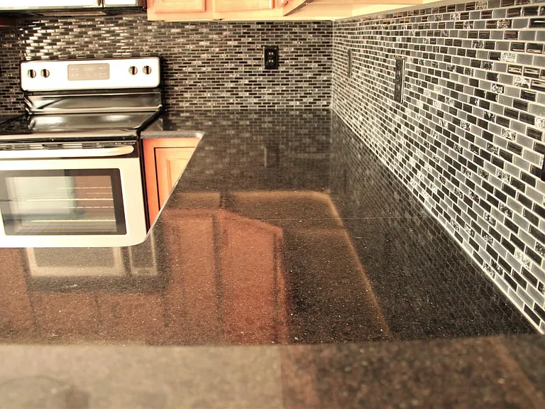 Black broken glass tile back splash.