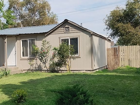 This photo displays the low maintenance front yard with various shrubs and the coziness of the property.