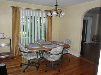 Dining Room with Wood Floors & Arched Door ways to the Kitchen & Living Room..