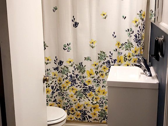 updated bathroom with vinyl plank flooring, storage vanity, tub shower and good size linen closet