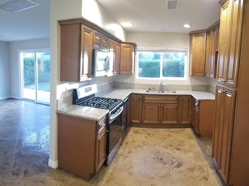 The kitchen is backed up to the living room. You can see you have a nice view of the backyard out of the kitchen window as well as the sliding glass door.