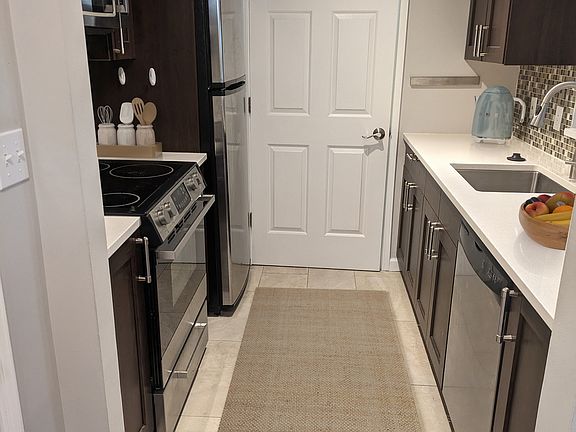 Kitchen with electric stove, dishwasher, microwave, refrigerator, and disposal. Access to walk-in pantry and laundry.