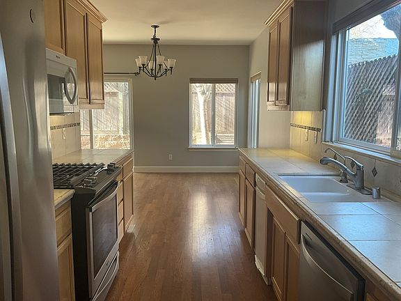Galley kitchen with refrigerator, dishwasher, Microwave and oven/range