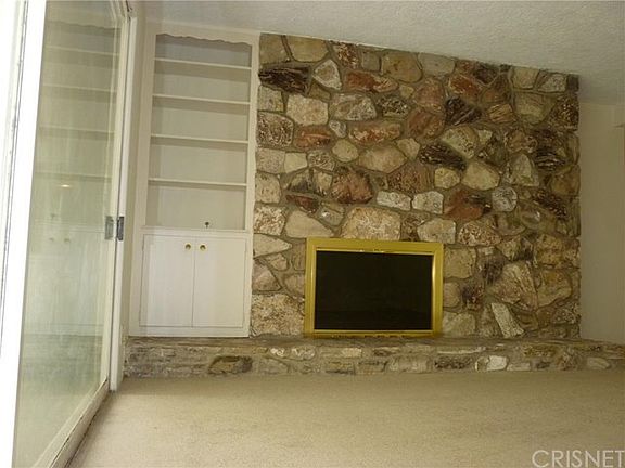 Living Room with Stone Fireplace and Built-In Bookcase