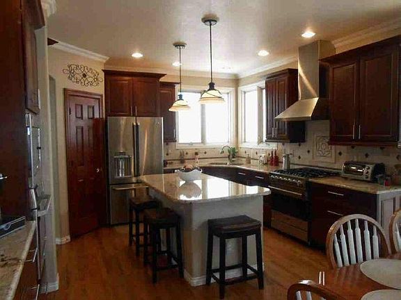 Update Kitchen with a Wolf range, GE Cafe double oven, refrigerator/freezer and dishwasher. Has an eat-in kitchen with direct access to deck.