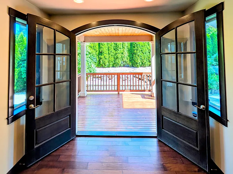 Solid wood French door opens into covered wood patio