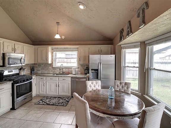 Breakfast room with bay window overlooking backyard, tile floor for easy maintenance.