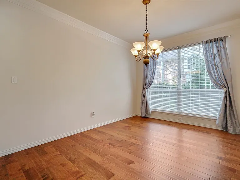 Formal dining room featuring large window, crown molding and wood floors