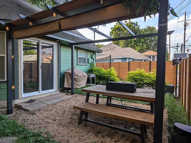 Outdoor dining area under a retractable pergola with easy access from the inside dining area via the sliding doors