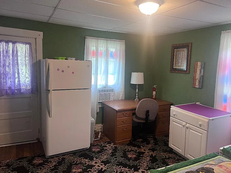 First floor work area. Full size fridge and desk, closet