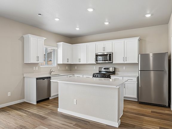 The kitchen has stainless steel appliances and white cabinets.