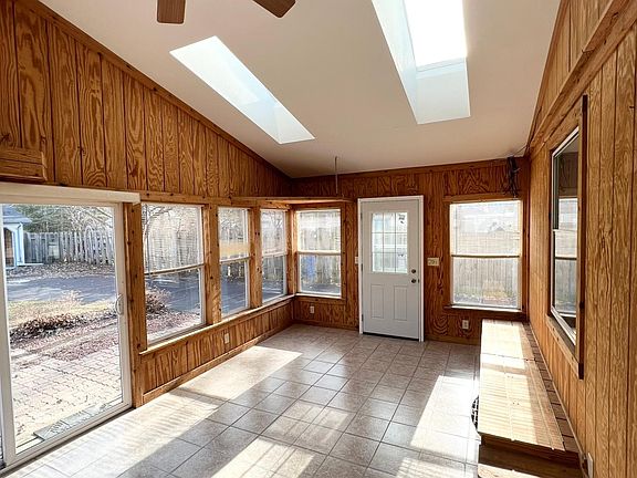 Large sunroom with vaulted ceilings and skylights off the patio