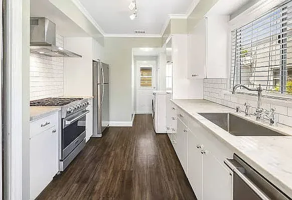 Kitchen with quartz countertops, Viking oven, stainless steel appliances, dishwasher, washer & dryer