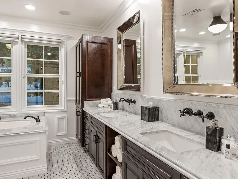 Revel in dual opulence with his and hers sinks in the bathroom, complemented by a lavish marble bathtub.