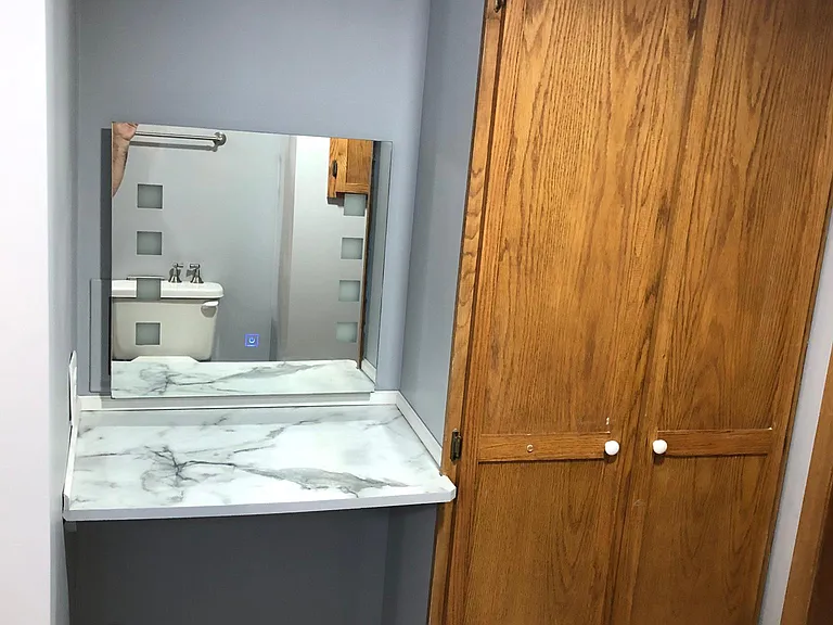 Large, solid oak linen cabinet next to custom makeup vanity